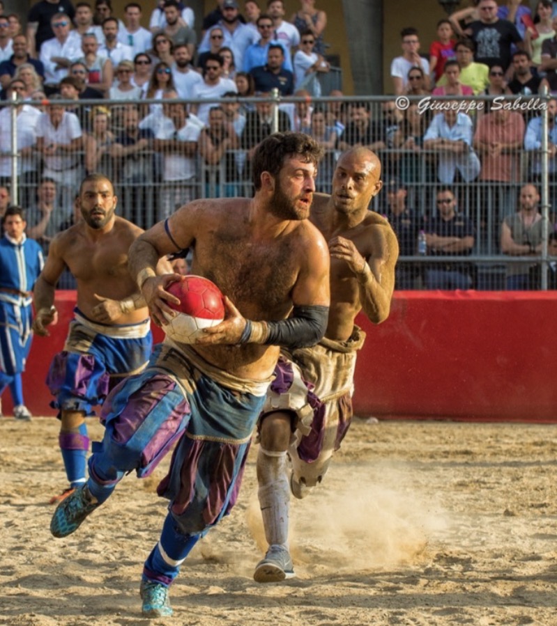Players running with the ball during a modern calcio storico match, photographed by Giuseppe Sabella